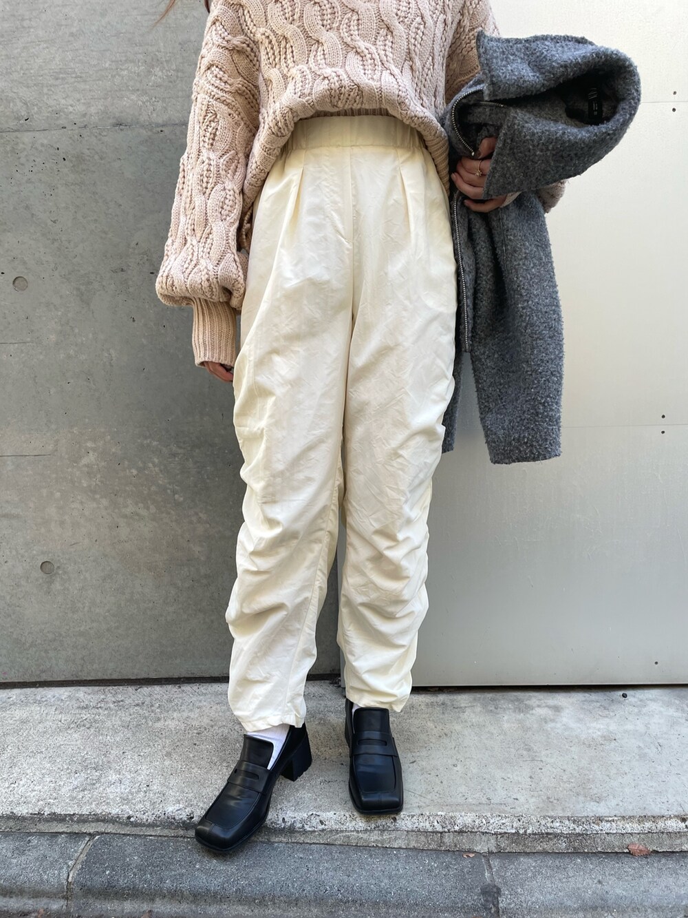 ベージュ系のニット/セーター、グレー系のジャケット/アウターを着用したレディースの春コーディネートの4枚目の写真