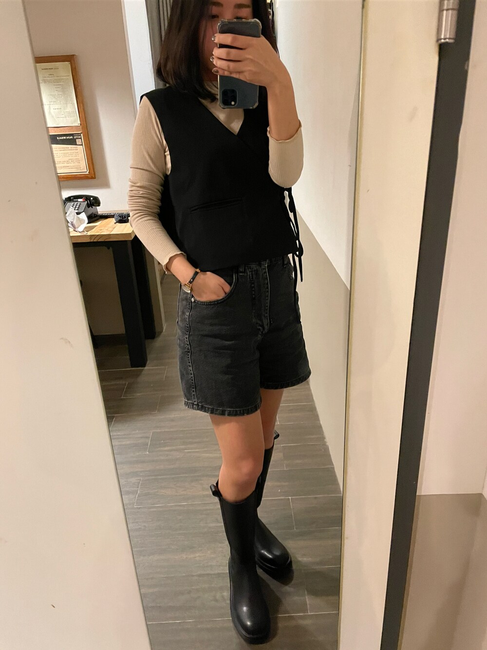 ブラック系のベスト、ベージュ系のトップス、ブラック系のパンツを着用したレディースの秋コーディネートの2枚目の写真