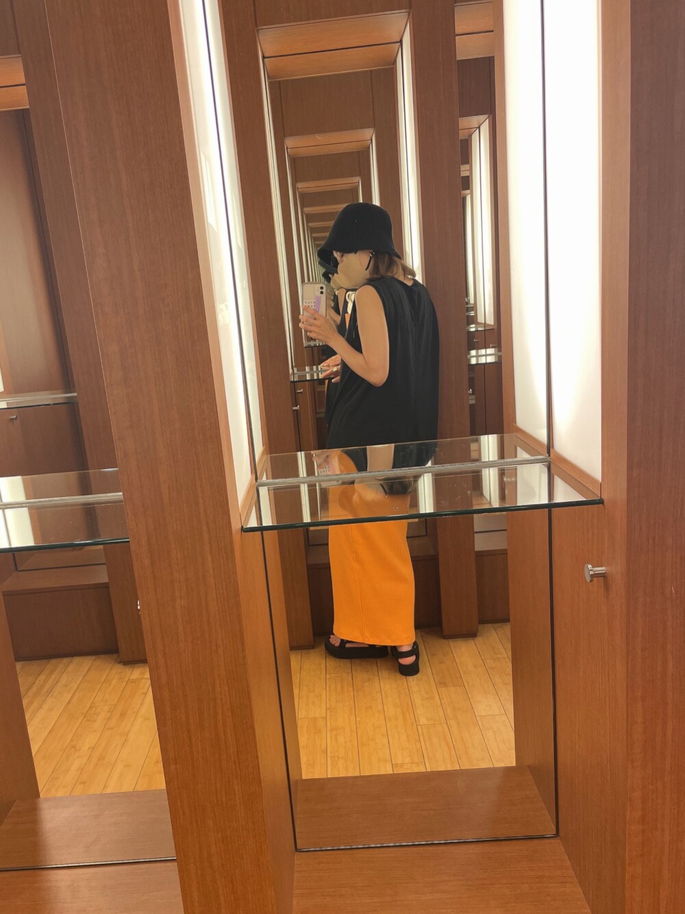 ブラック系のタンクトップ、ブラック系のサンダル、ブラック系のハットを着用したレディースの夏コーディネートの2枚目の写真