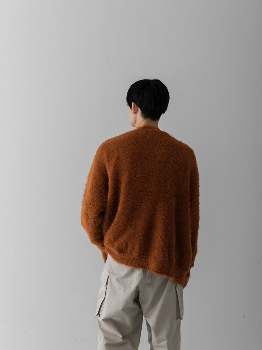 レッド系のカーディガン/ボレロ、ベージュ系のその他パンツを着用したメンズの冬コーディネートの3枚目の写真