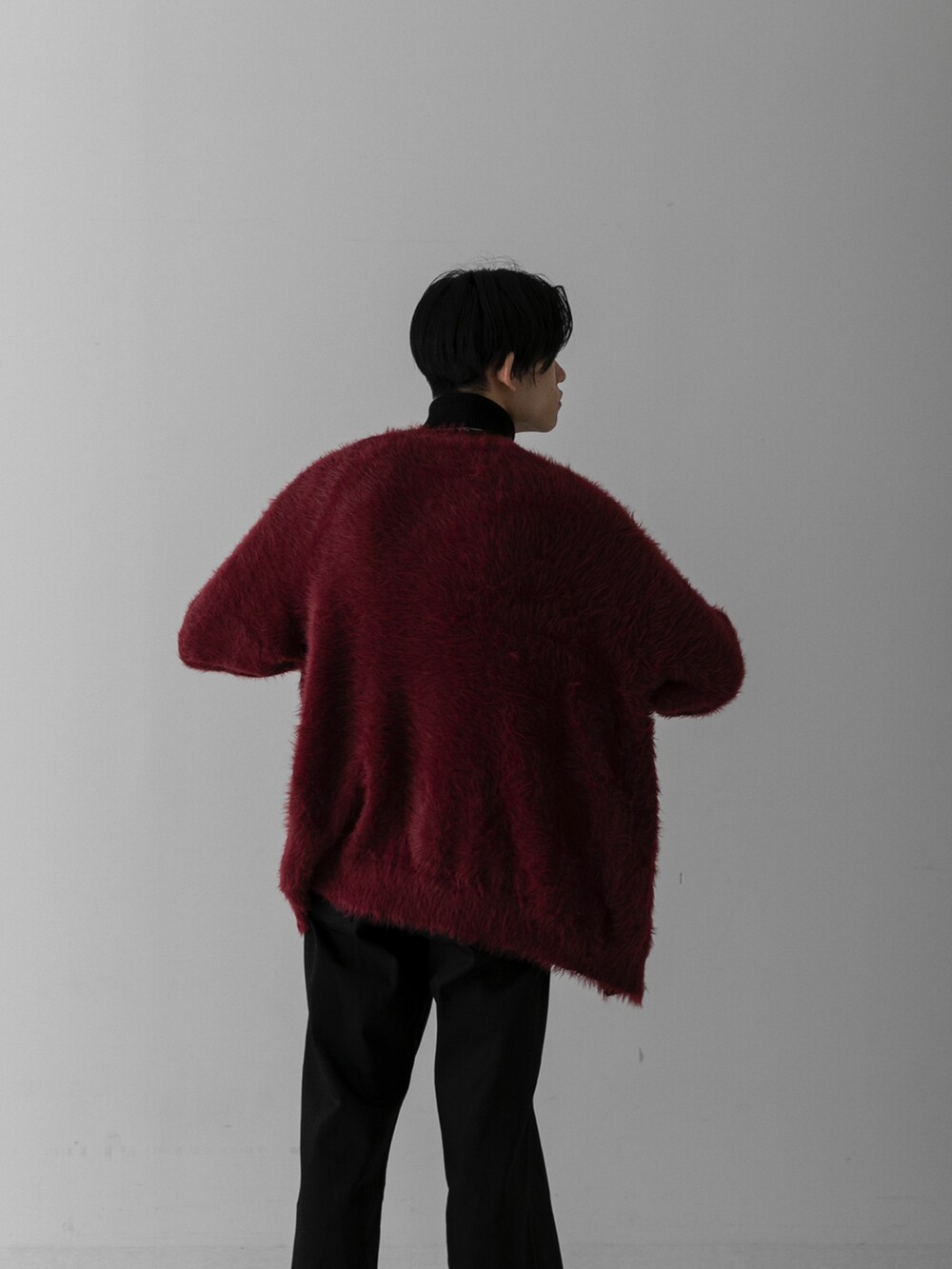 ブラック系のスラックス、レッド系のカーディガン/ボレロ、ホワイト系のニット/セーターを着用したメンズの冬コーディネートの4枚目の写真