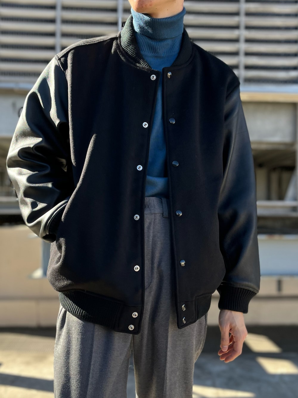 ブラック系のその他パンツ、ブラック系のスタジャン、ホワイト系のニット/セーターを着用したメンズの冬コーディネートの2枚目の写真