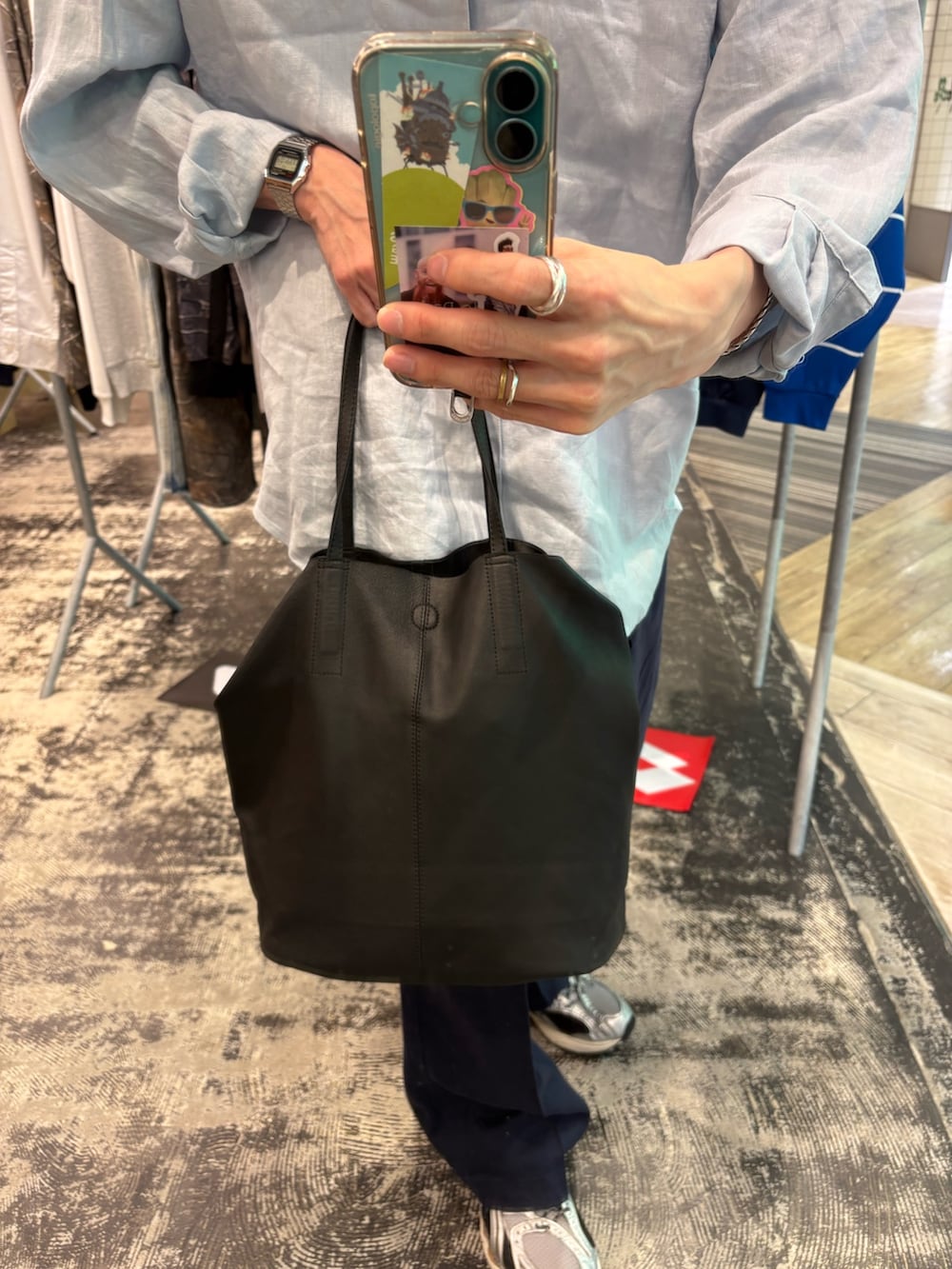 シルバー系のスニーカー、ブラック系のショルダーバッグ、ブルー系のその他パンツを着用したメンズの春コーディネートの4枚目の写真