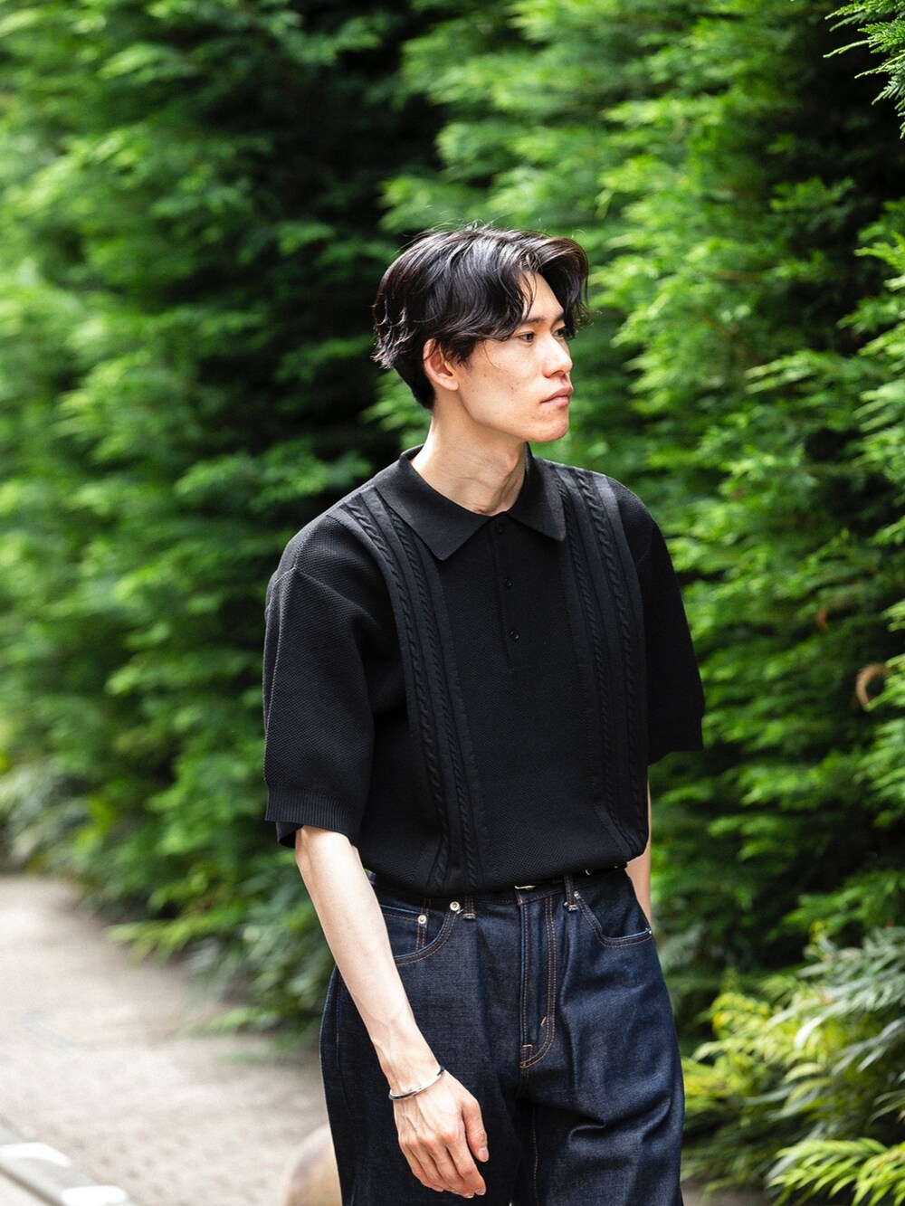 ブルー系のデニムパンツ、ブラック系のトップスを着用したメンズの春コーディネートの2枚目の写真