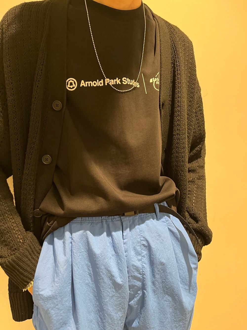 ホワイト系のスニーカー、ブラック系のトップス、ブルー系のパンツを着用したメンズの夏コーディネートの2枚目の写真