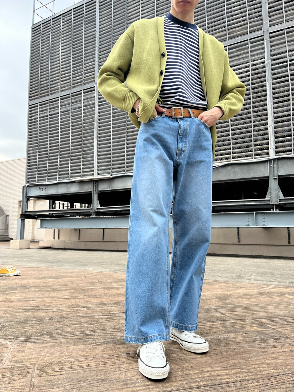 ブルー系のデニムパンツ、ブルー系のTシャツ/カットソー、イエロー系のカーディガン/ボレロを着用したメンズの冬コーディネートの3枚目の写真