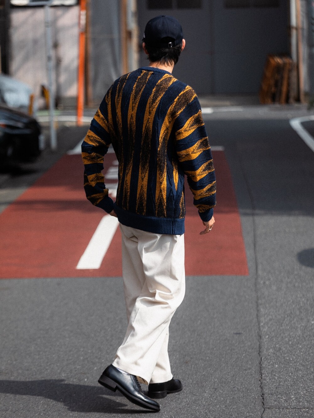 グリーン系のニット/セーター、パープル系のキャップ、シルバー系のネックレスを着用したメンズの冬コーディネートの2枚目の写真