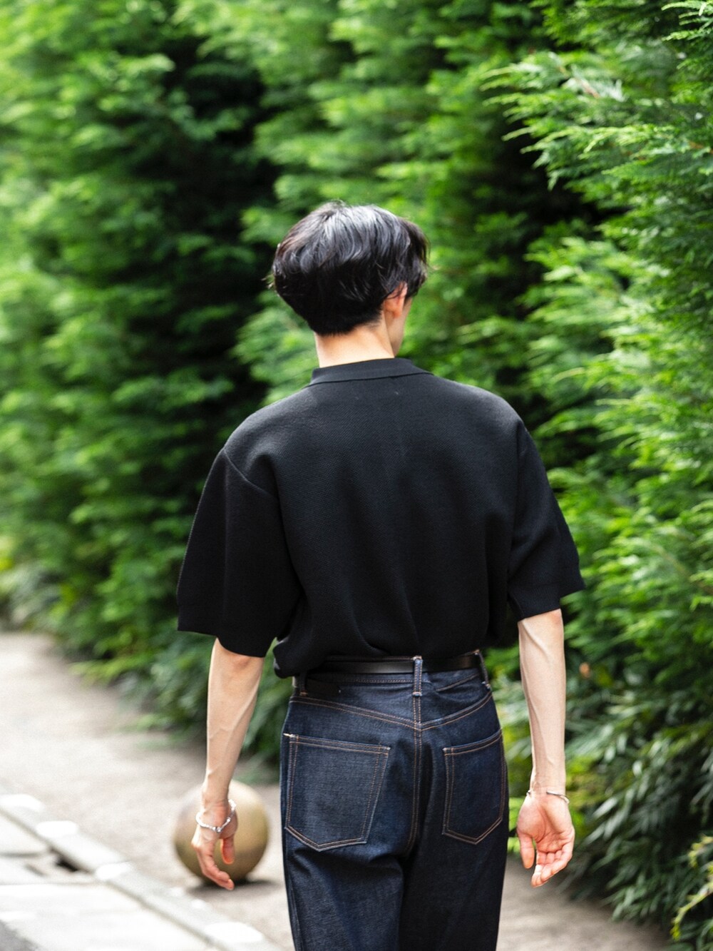 ブルー系のデニムパンツ、ブラック系のトップスを着用したメンズの春コーディネートの3枚目の写真