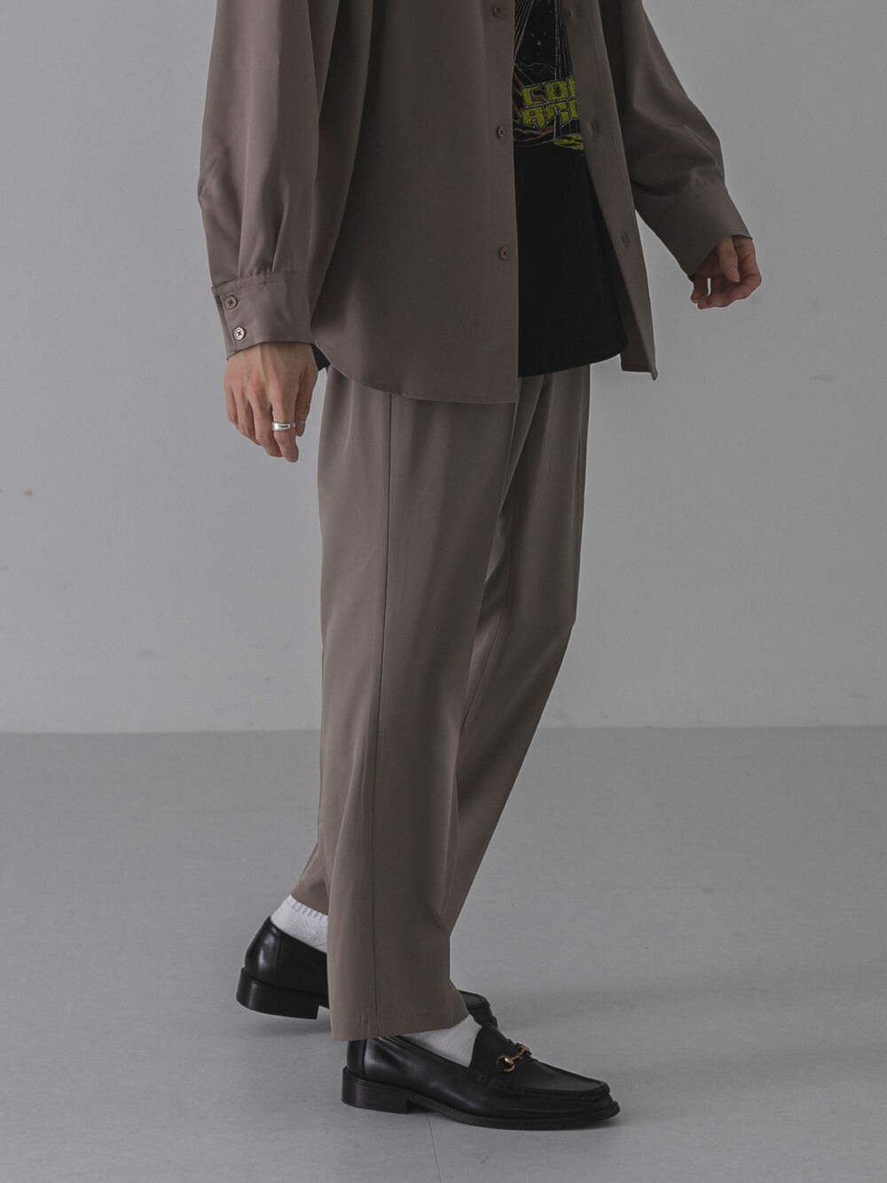 ブラック系のローファー、ベージュ系のその他パンツ、ブラック系のTシャツ/カットソーを着用したメンズの秋コーディネートの4枚目の写真