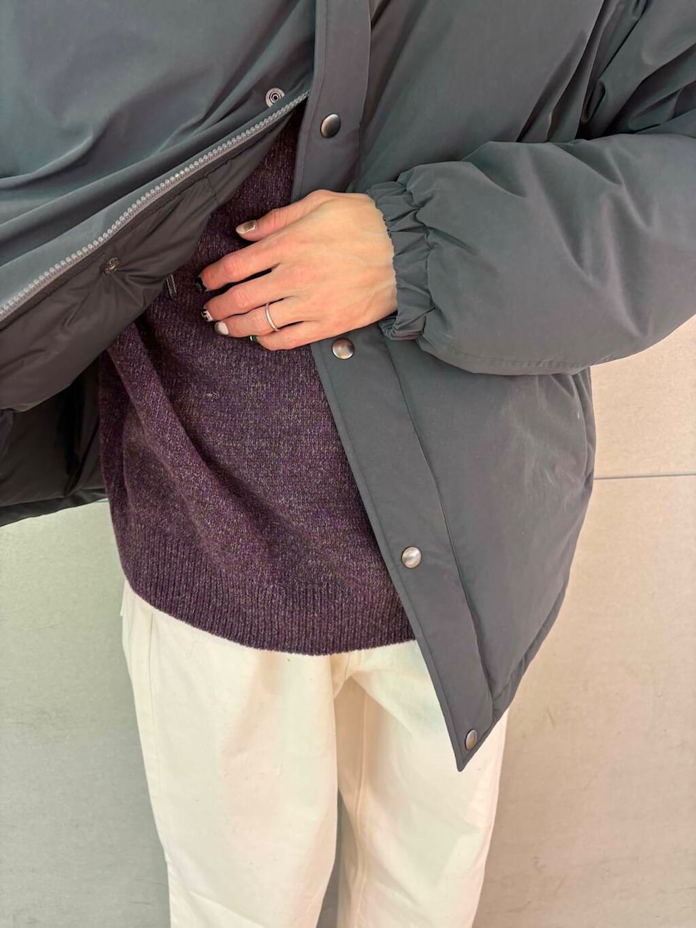 ブラック系のダウンジャケット/コート、パープル系のニット/セーター、ホワイト系のデニムパンツを着用したメンズの冬コーディネートの3枚目の写真