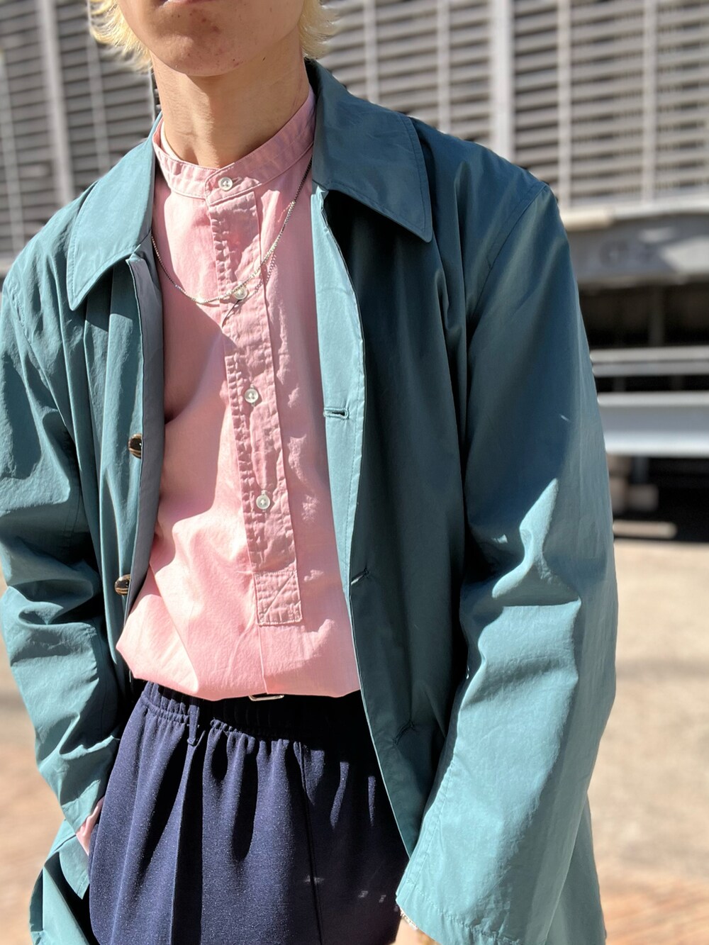 ブラック系のシューズ、グリーン系のその他パンツ、グリーン系のステンカラーコートを着用したメンズの春コーディネートの3枚目の写真