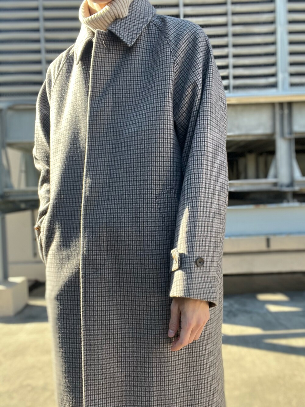ブルー系のデニムパンツ、ベージュ系のステンカラーコート、ベージュ系のニット/セーターを着用したメンズの冬コーディネートの2枚目の写真