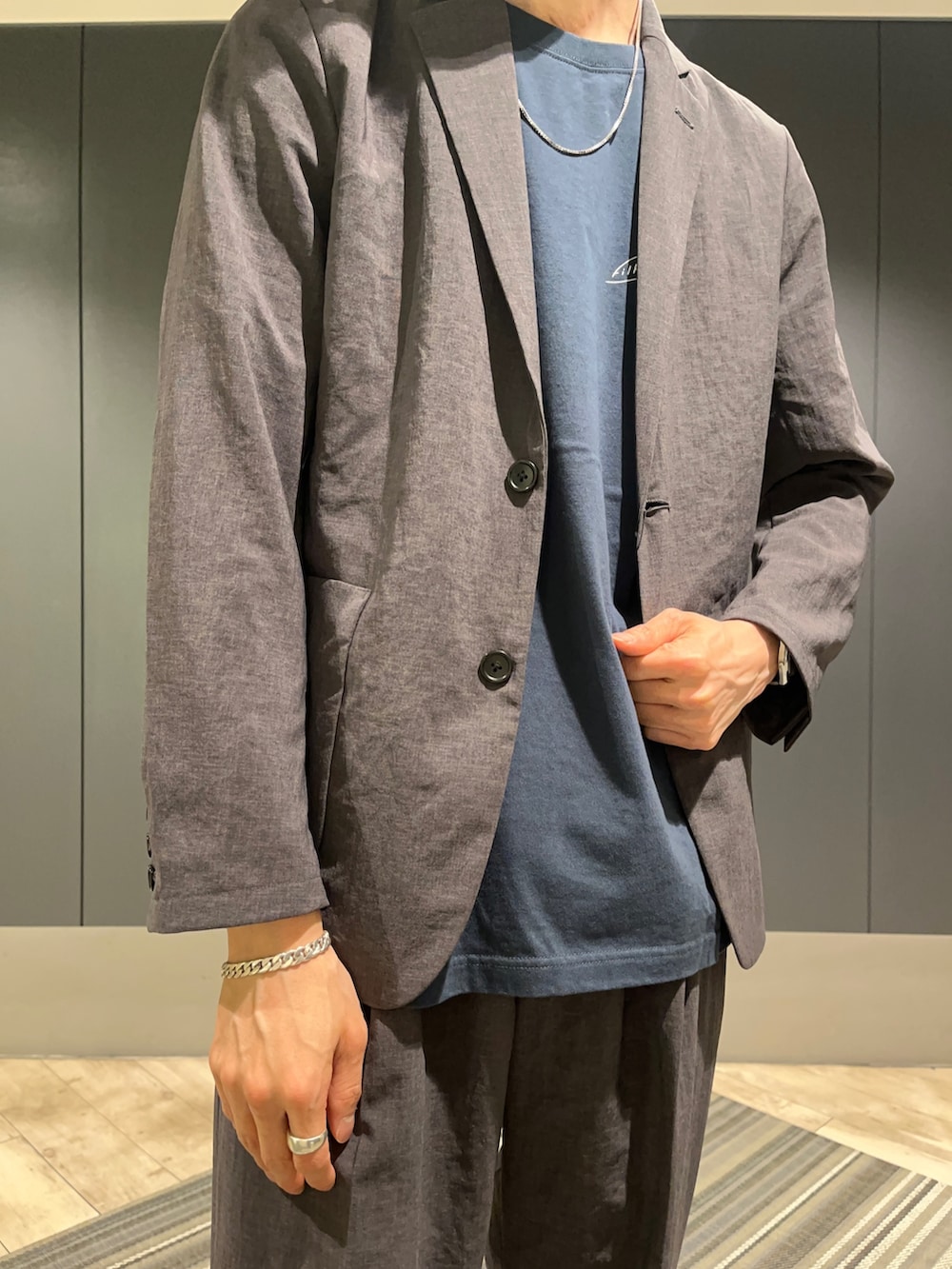 グレー系のその他パンツ、ブルー系のTシャツ/カットソー、グレー系のセットアップを着用したメンズの春コーディネートの2枚目の写真