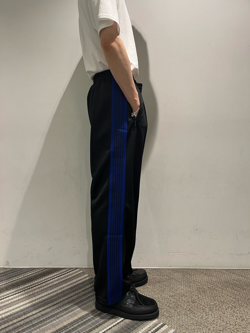 ブラック系のパンツ、ホワイト系のTシャツ/カットソー、パープル系のキャップを着用したメンズの夏コーディネートの2枚目の写真