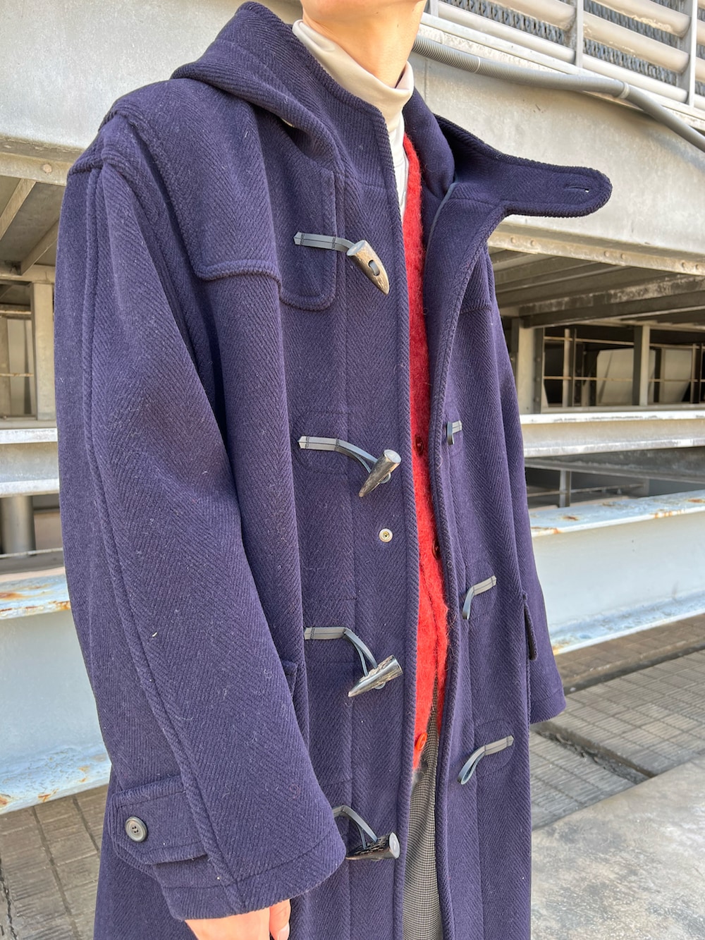 ブラウン系のモカシン/デッキシューズ、ブルー系のダッフルコート、オレンジ系のカーディガン/ボレロを着用したメンズの秋コーディネートの3枚目の写真