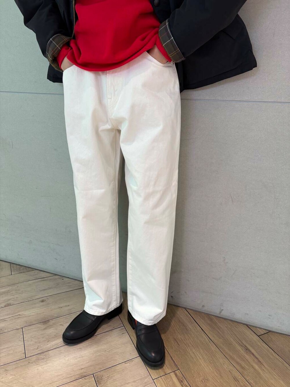 レッド系のスウェット、ホワイト系のデニムパンツ、ブラック系のダウンジャケット/コートを着用したメンズの冬コーディネートの3枚目の写真