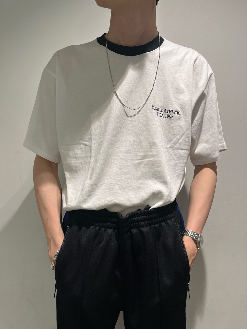 ブラック系のパンツ、ホワイト系のTシャツ/カットソー、パープル系のキャップを着用したメンズの夏コーディネートの3枚目の写真