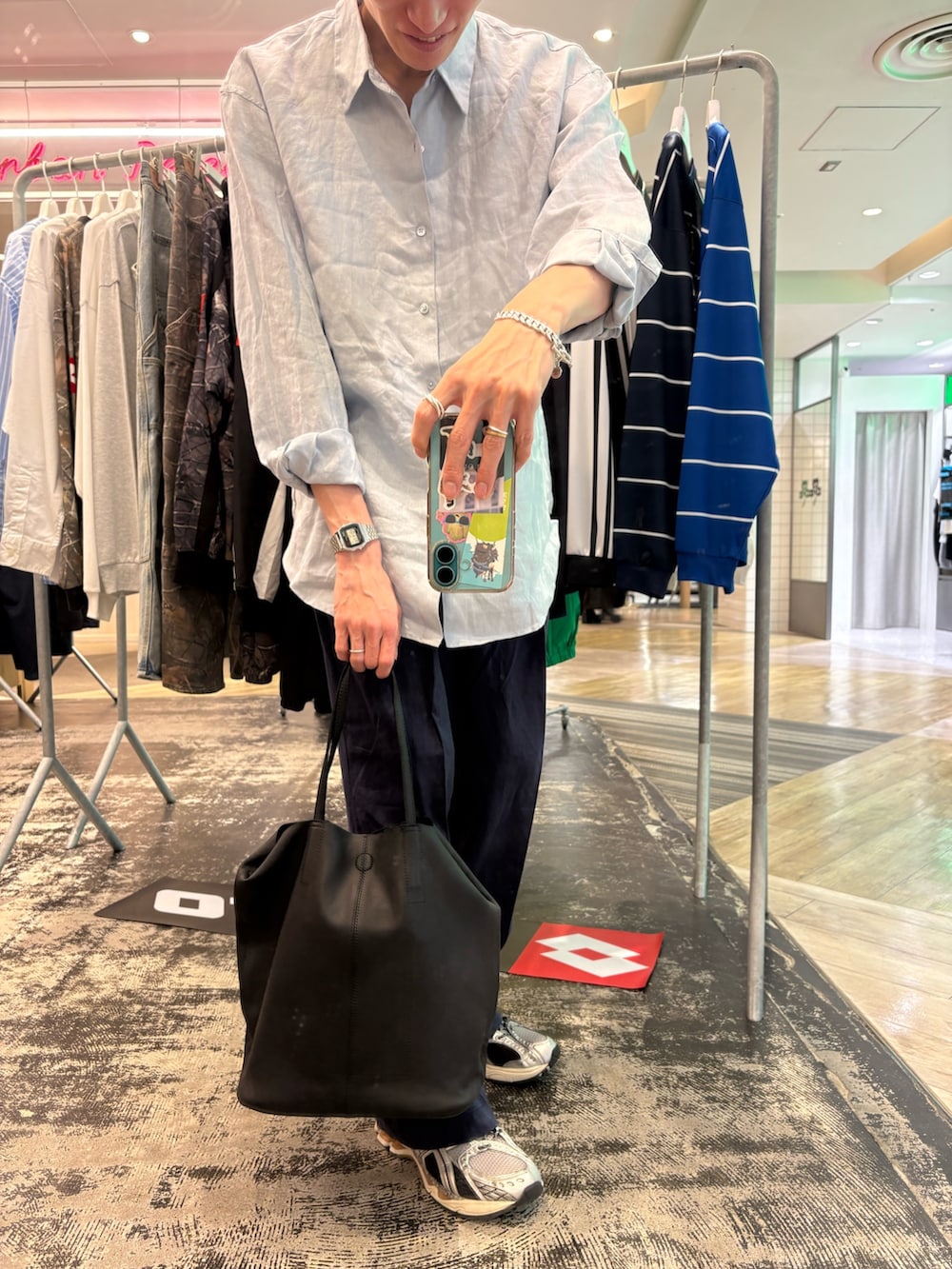 シルバー系のスニーカー、ブラック系のショルダーバッグ、ブルー系のその他パンツを着用したメンズの春コーディネートの3枚目の写真