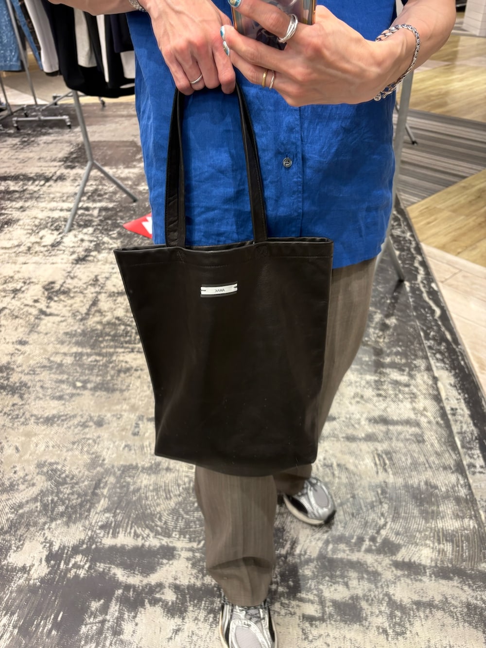 ブルー系のシャツ/ブラウス、ブラック系のトートバッグ、ブラウン系のその他パンツを着用したメンズの夏コーディネートの3枚目の写真