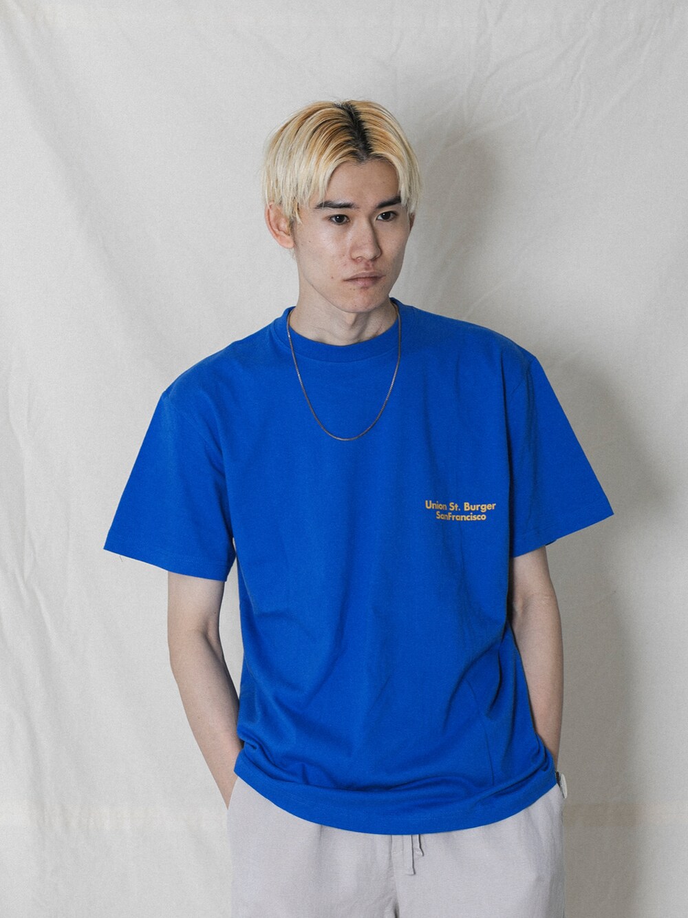 ホワイト系のTシャツ/カットソー、グレー系のその他パンツ、ホワイト系のサンダルを着用したメンズの夏コーディネートの2枚目の写真