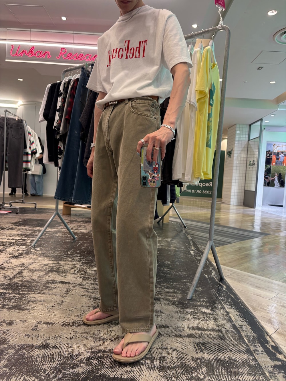 ベージュ系のデニムパンツ、ベージュ系のサンダル、ホワイト系のTシャツ/カットソーを着用したメンズの夏コーディネートの2枚目の写真