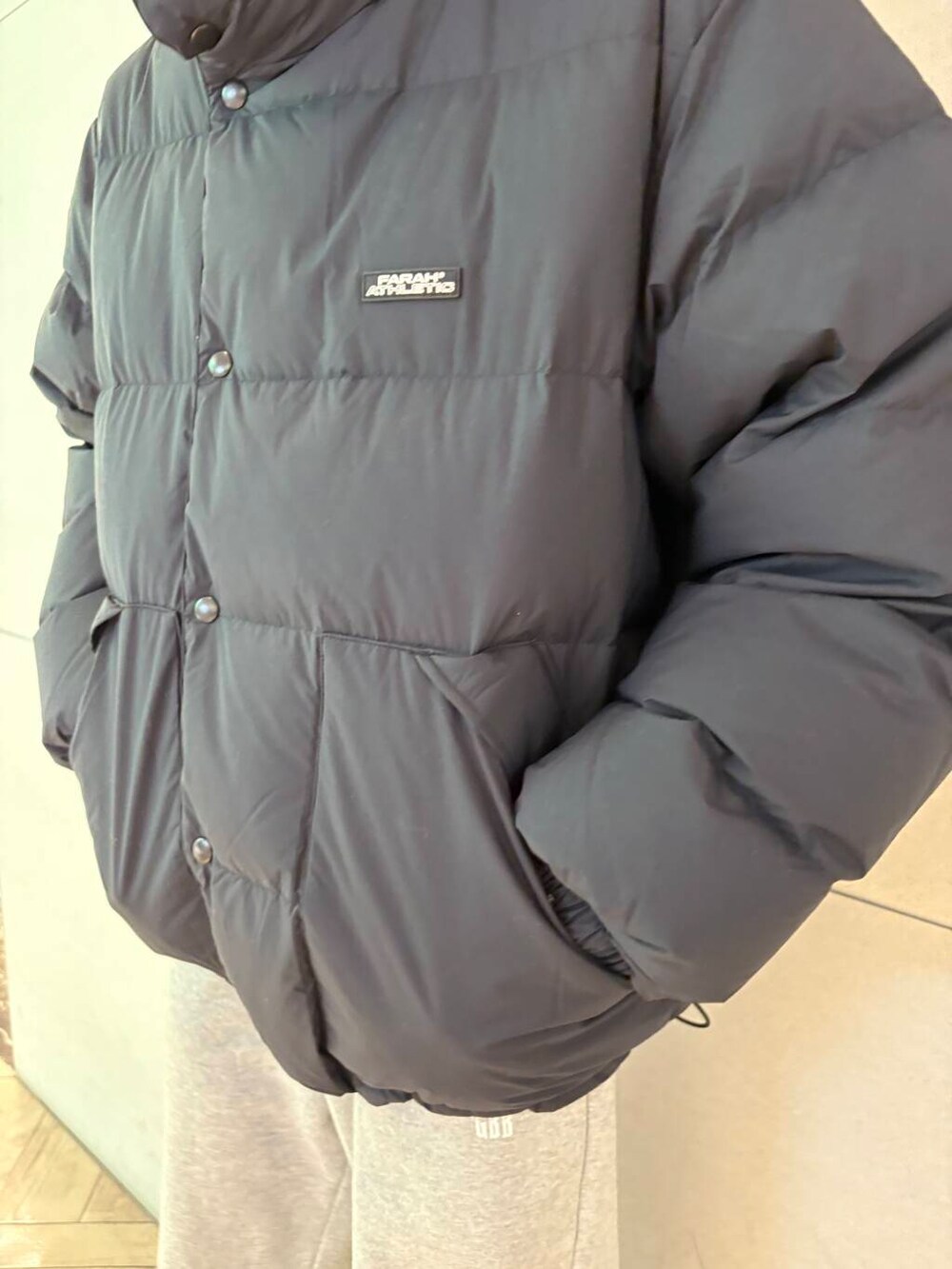 グレー系のその他パンツ、ブラック系のダウンジャケット/コートを着用したメンズの冬コーディネートの2枚目の写真