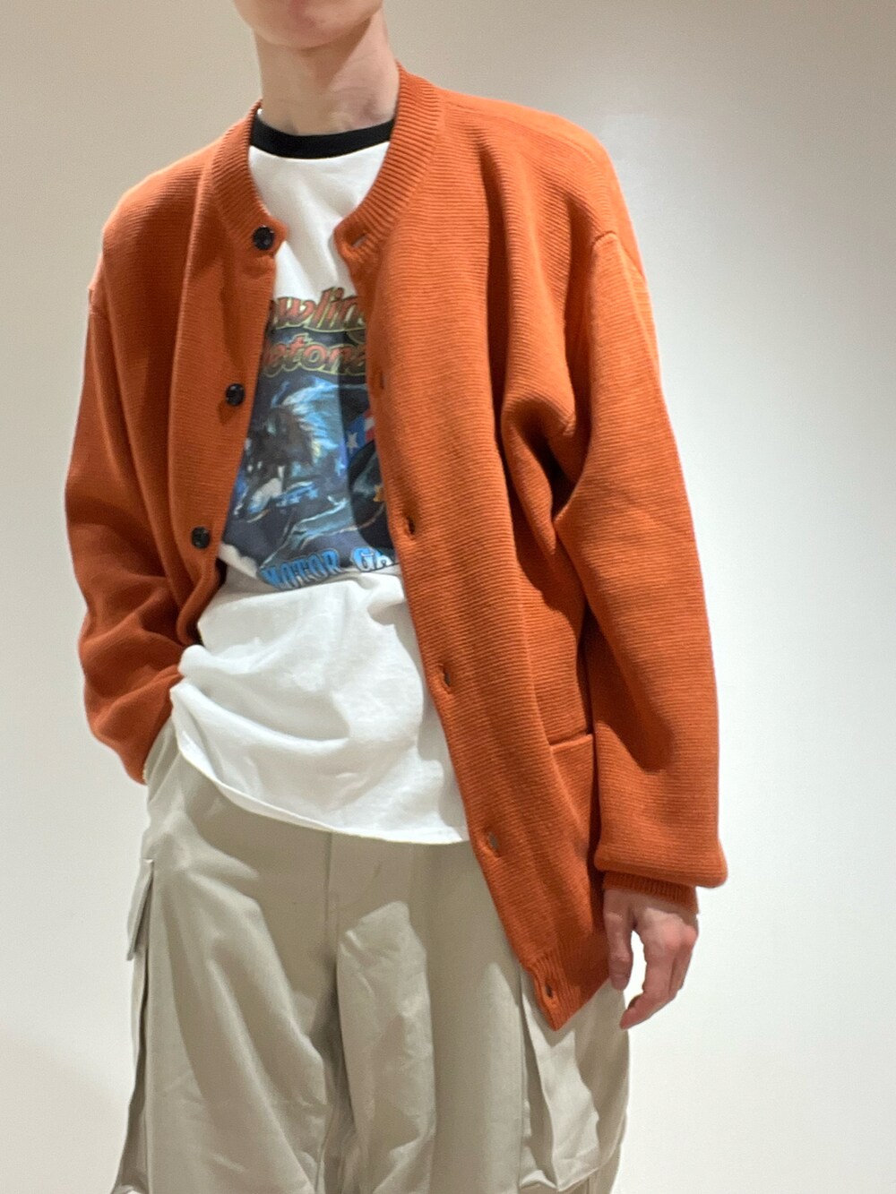 ベージュ系のその他パンツ、ブラック系のTシャツ/カットソー、オレンジ系のカーディガン/ボレロを着用したメンズの秋コーディネートの3枚目の写真