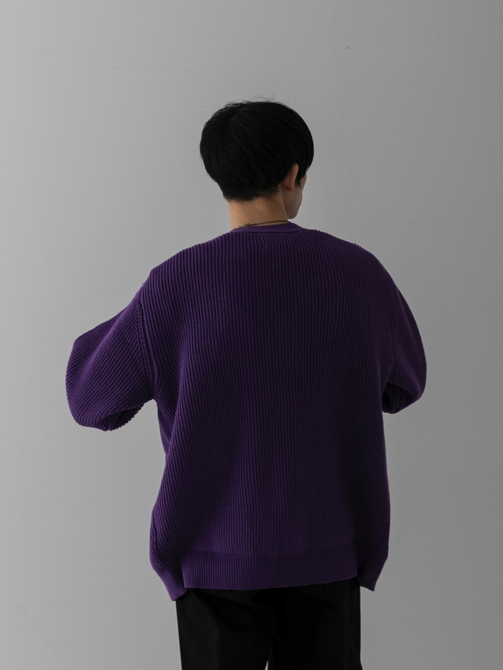 パープル系のカーディガン/ボレロ、ホワイト系のスウェット、ブラック系のデニムパンツを着用したメンズの冬コーディネートの4枚目の写真