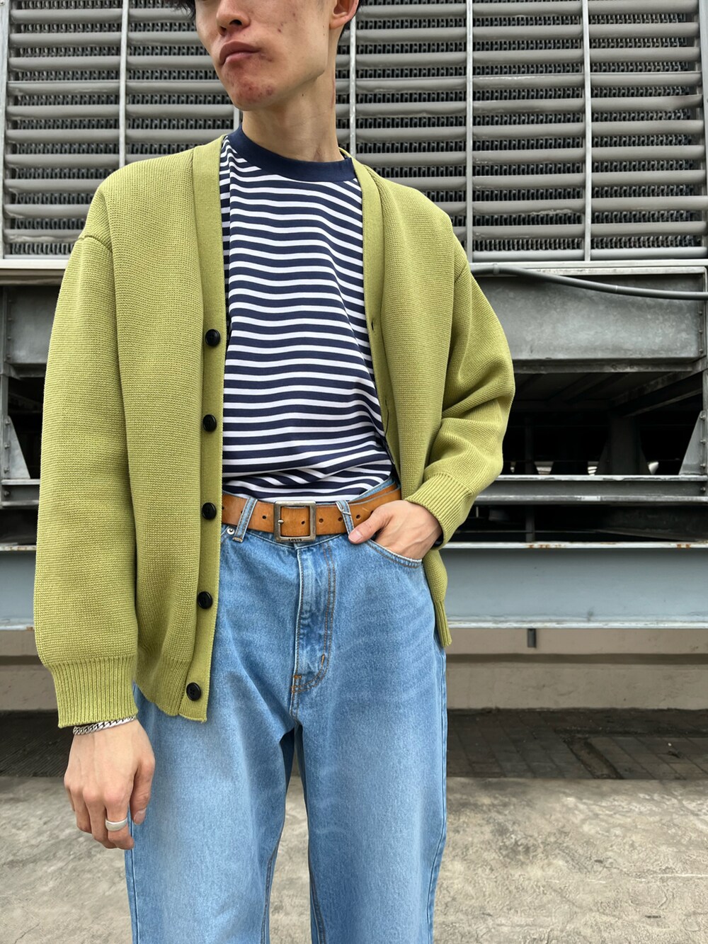 ブルー系のデニムパンツ、ブルー系のTシャツ/カットソー、イエロー系のカーディガン/ボレロを着用したメンズの冬コーディネートの2枚目の写真