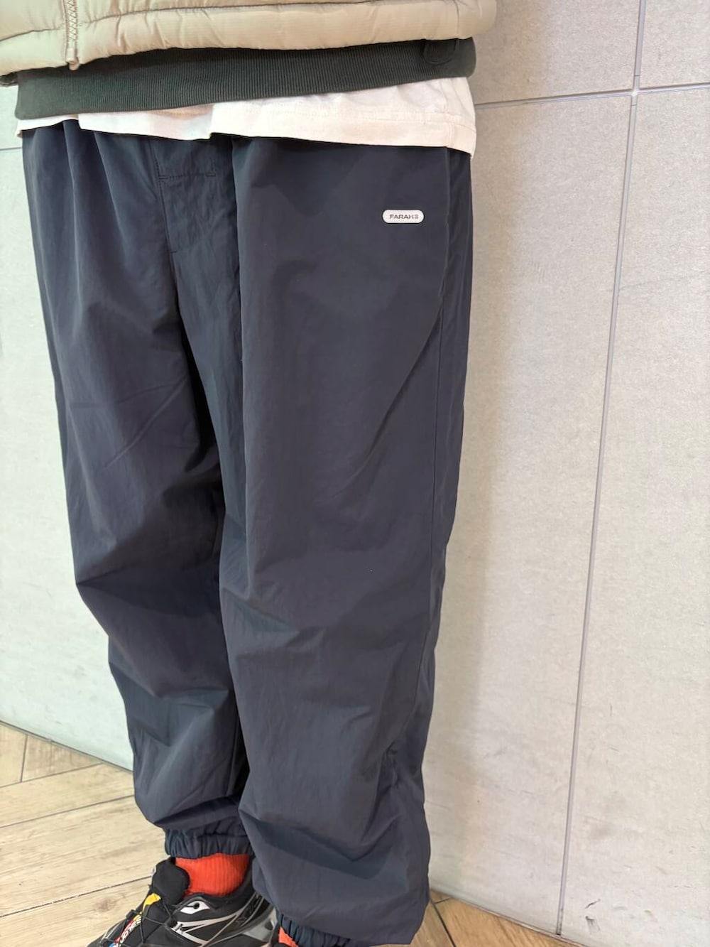 グレー系のダウンベスト、ブラック系のその他パンツ、ブラック系のスウェットを着用したメンズの冬コーディネートの3枚目の写真