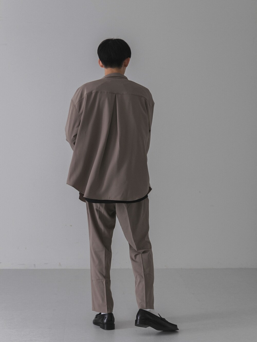 ブラック系のローファー、ベージュ系のその他パンツ、ブラック系のTシャツ/カットソーを着用したメンズの秋コーディネートの2枚目の写真