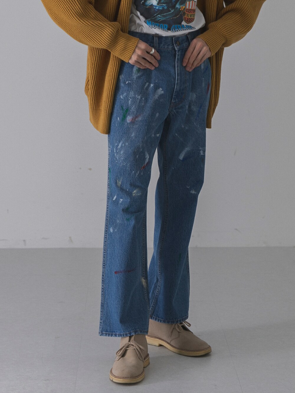 ゴールド系のカーディガン/ボレロ、ブラック系のTシャツ/カットソー、ブルー系のデニムパンツを着用したメンズの秋コーディネートの4枚目の写真