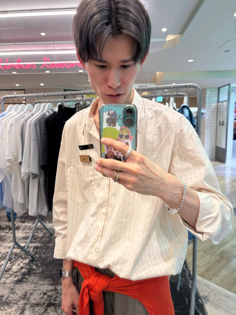 シルバー系のスニーカー、ブラウン系のその他パンツ、オレンジ系のニット/セーターを着用したメンズの春コーディネートの2枚目の写真