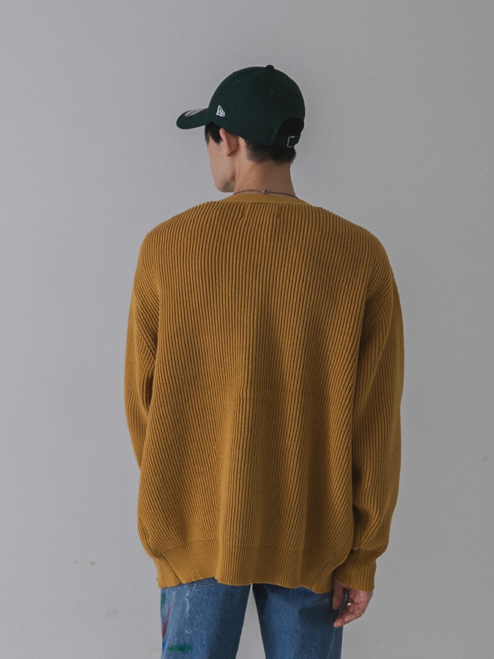 ゴールド系のカーディガン/ボレロ、ブラック系のTシャツ/カットソー、ブルー系のデニムパンツを着用したメンズの秋コーディネートの3枚目の写真