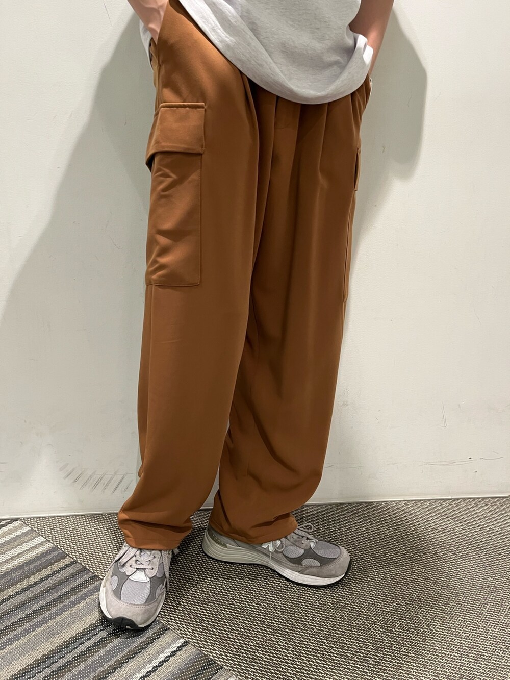 ホワイト系のトップス、ブラウン系のカーゴパンツ、シルバー系のネックレスを着用したメンズの夏コーディネートの3枚目の写真