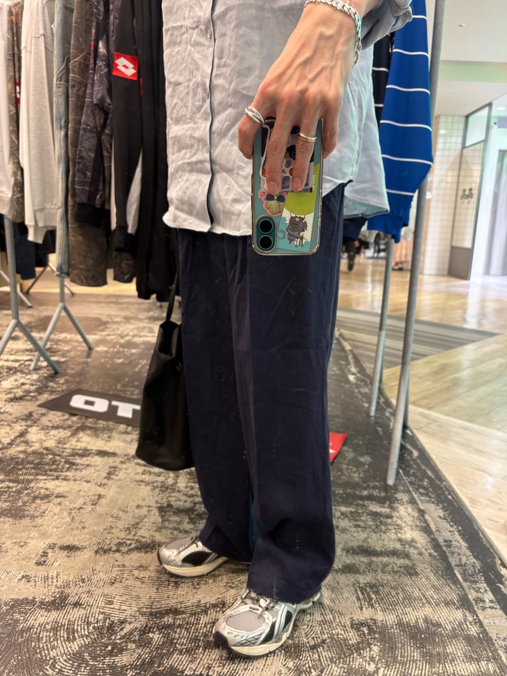 シルバー系のスニーカー、ブラック系のショルダーバッグ、ブルー系のその他パンツを着用したメンズの春コーディネートの5枚目の写真