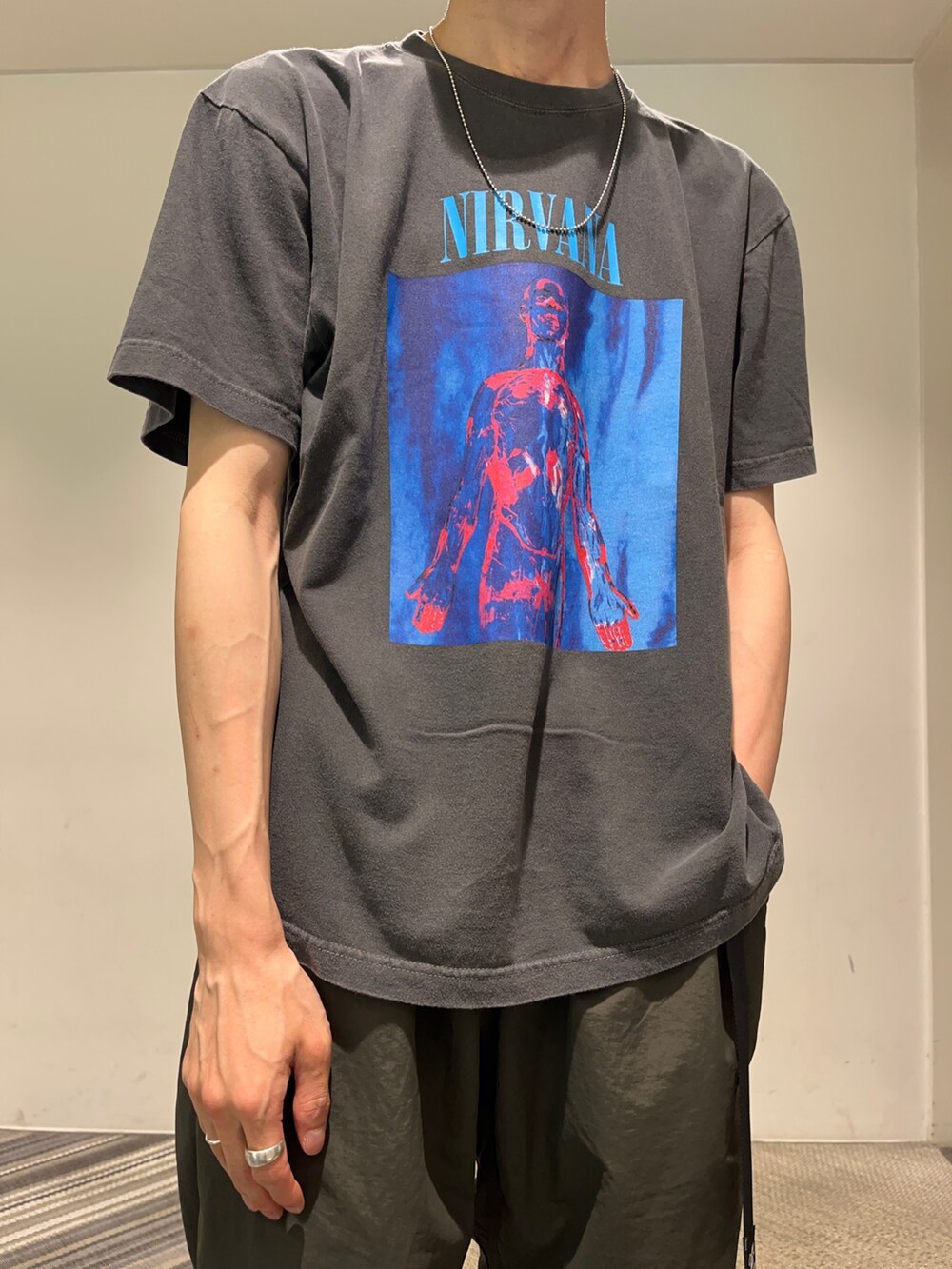 グリーン系のパンツ、ブラック系のTシャツ/カットソー、シルバー系のネックレスを着用したメンズの夏コーディネートの2枚目の写真