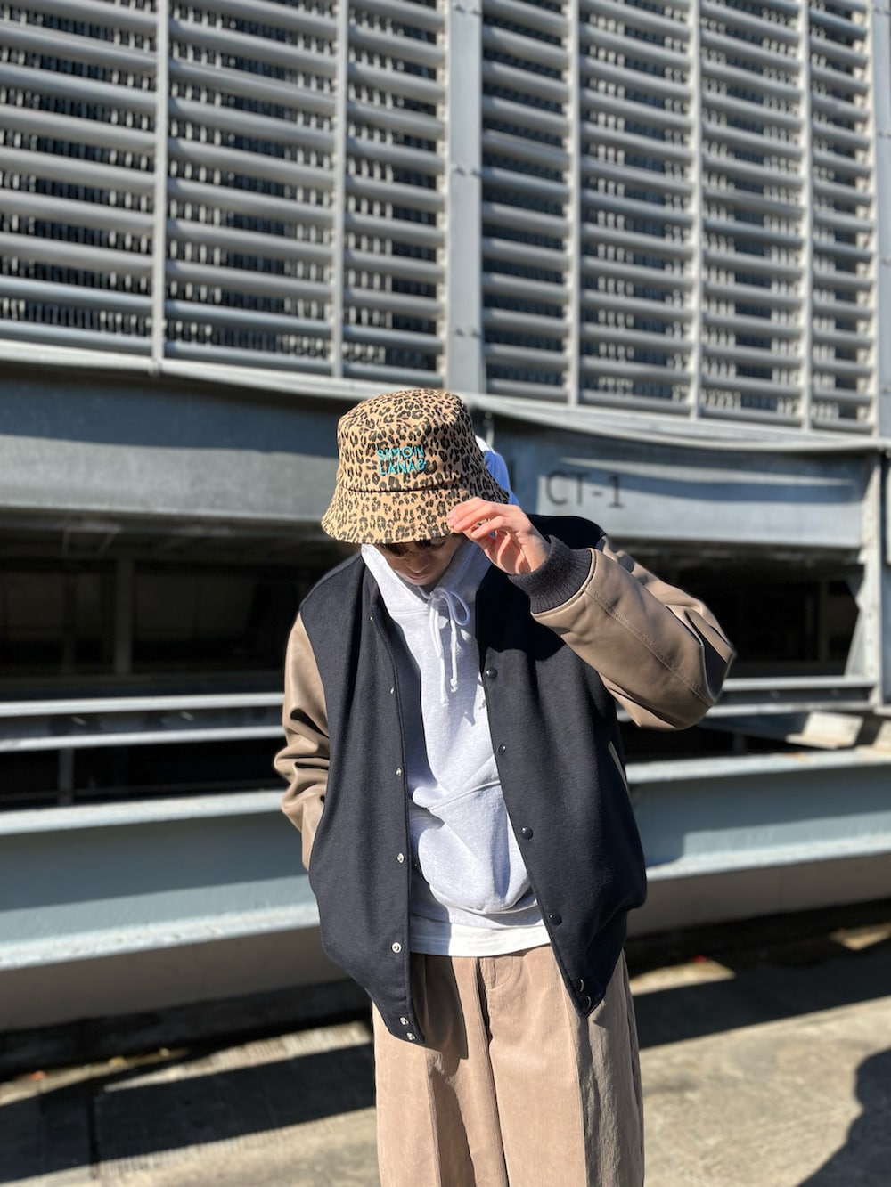 ベージュ系のその他パンツ、グレー系のパーカー、ブルー系のスタジャンを着用したメンズの冬コーディネートの2枚目の写真