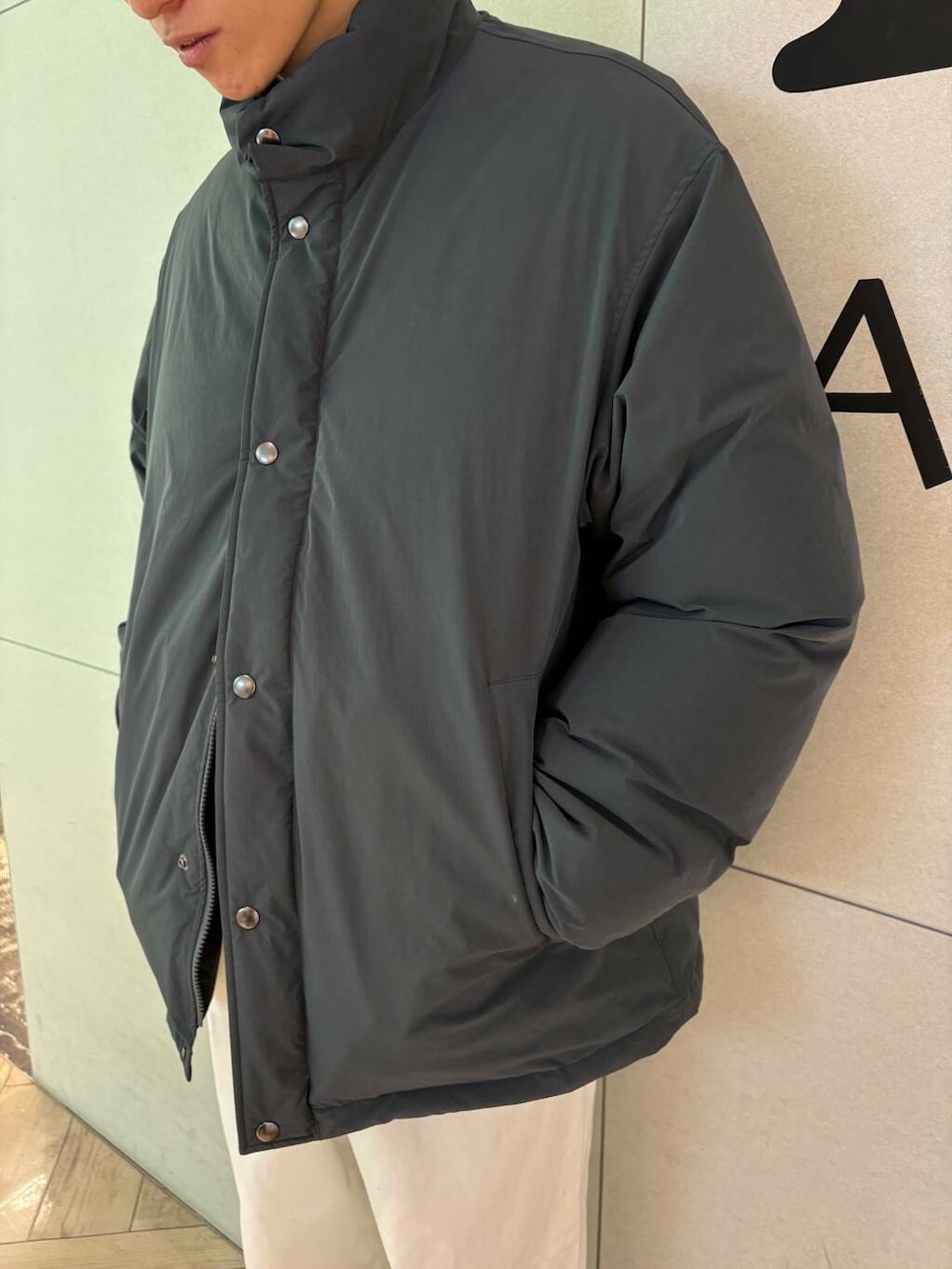 ブラック系のダウンジャケット/コート、パープル系のニット/セーター、ホワイト系のデニムパンツを着用したメンズの冬コーディネートの2枚目の写真