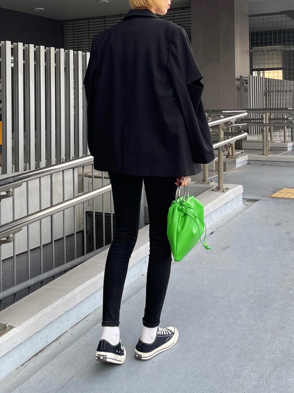 ベージュ系のその他アウター、グリーン系のハンドバッグ、ブラック系のデニムパンツを着用したレディースの冬コーディネートの2枚目の写真