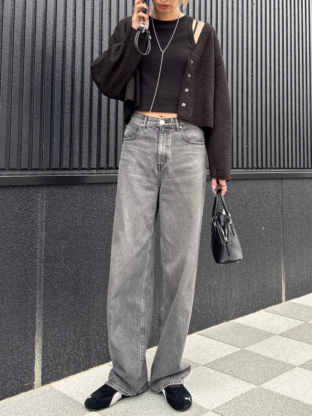 ブラック系のカーディガン/ボレロ、ブラック系のデニムパンツ、ブラック系のスニーカーを着用したレディースの秋コーディネートの2枚目の写真