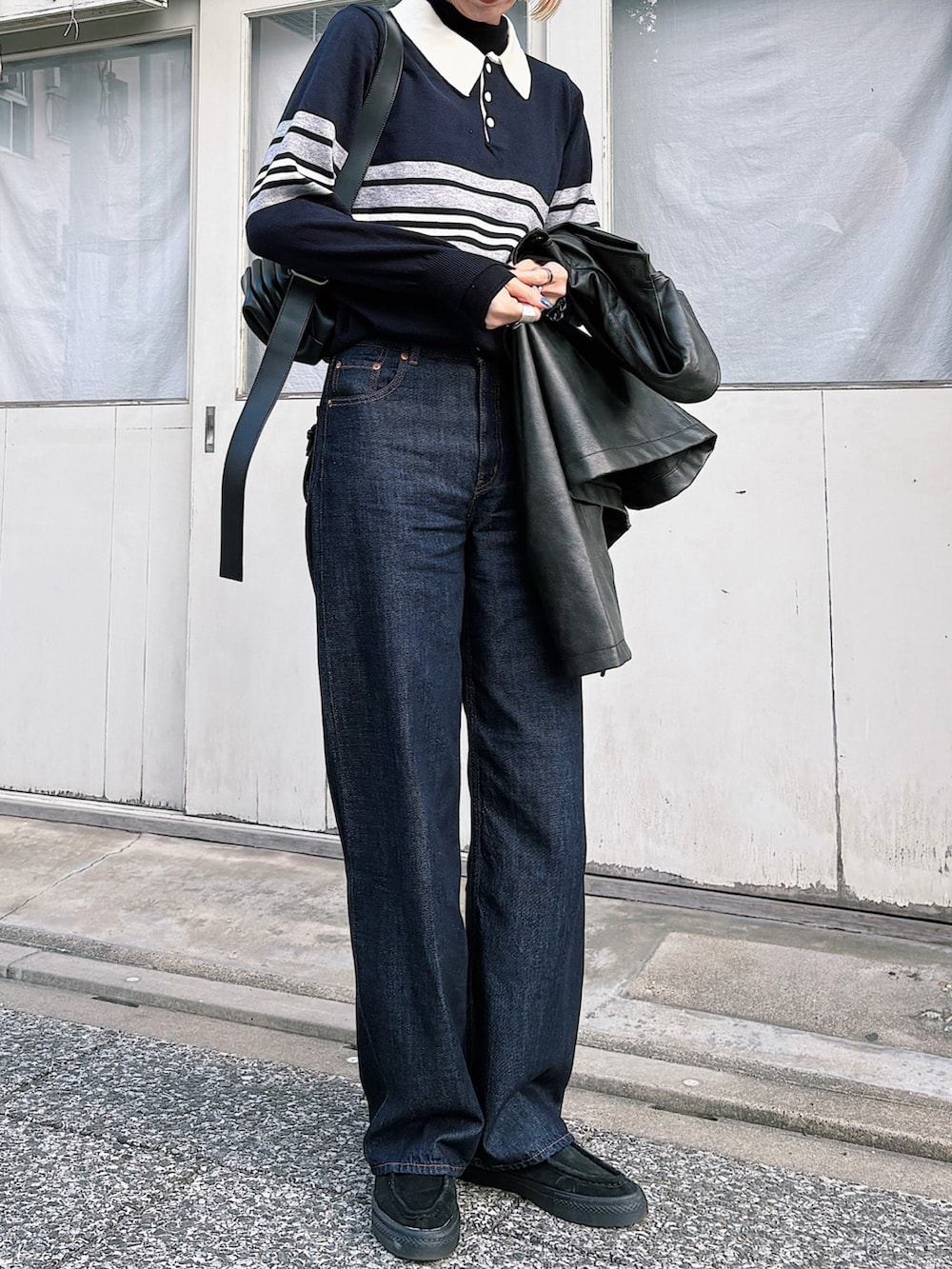 グレー系のニット/セーター、ブルー系のデニムパンツ、ブラック系のスニーカーを着用したレディースの冬コーディネートの2枚目の写真