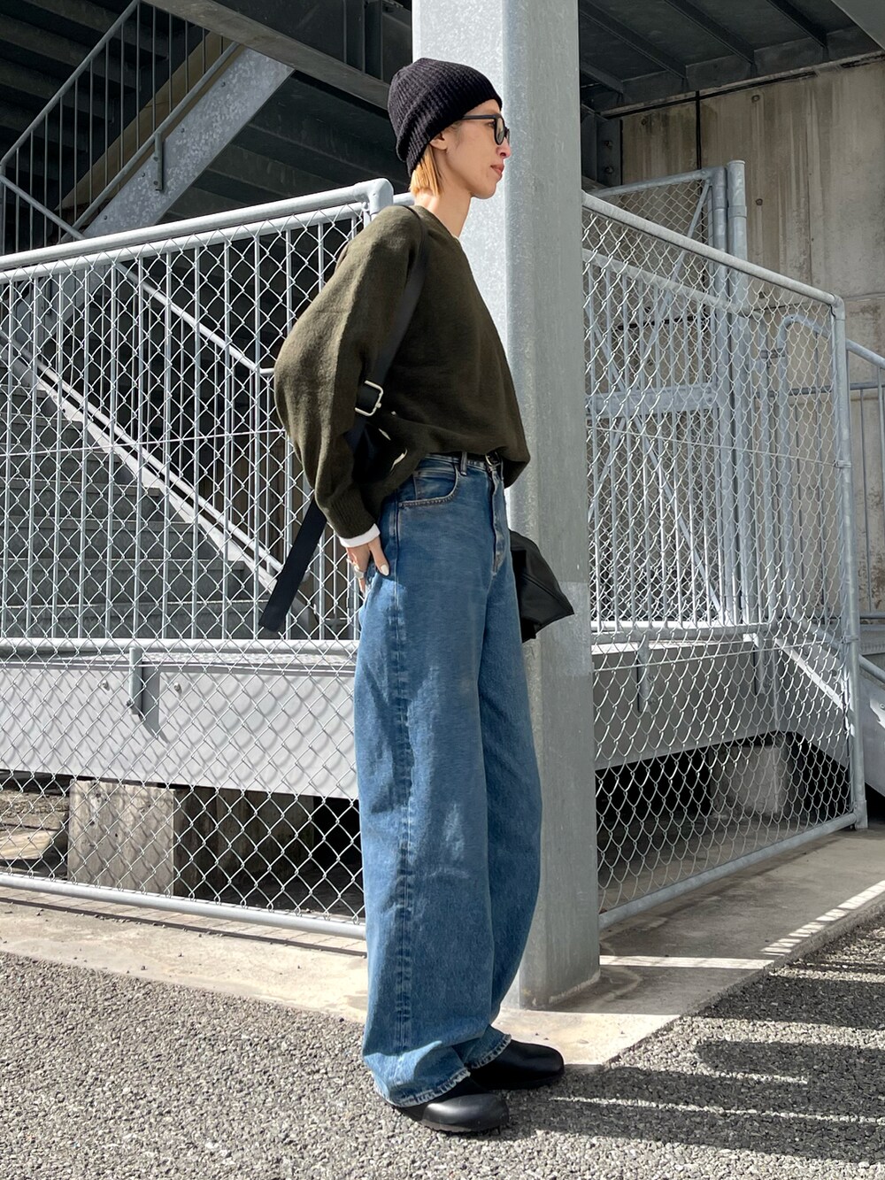 ブルー系のデニムパンツ、ブラック系のサンダル、ブラック系のショルダーバッグを着用したレディースの冬コーディネートの2枚目の写真
