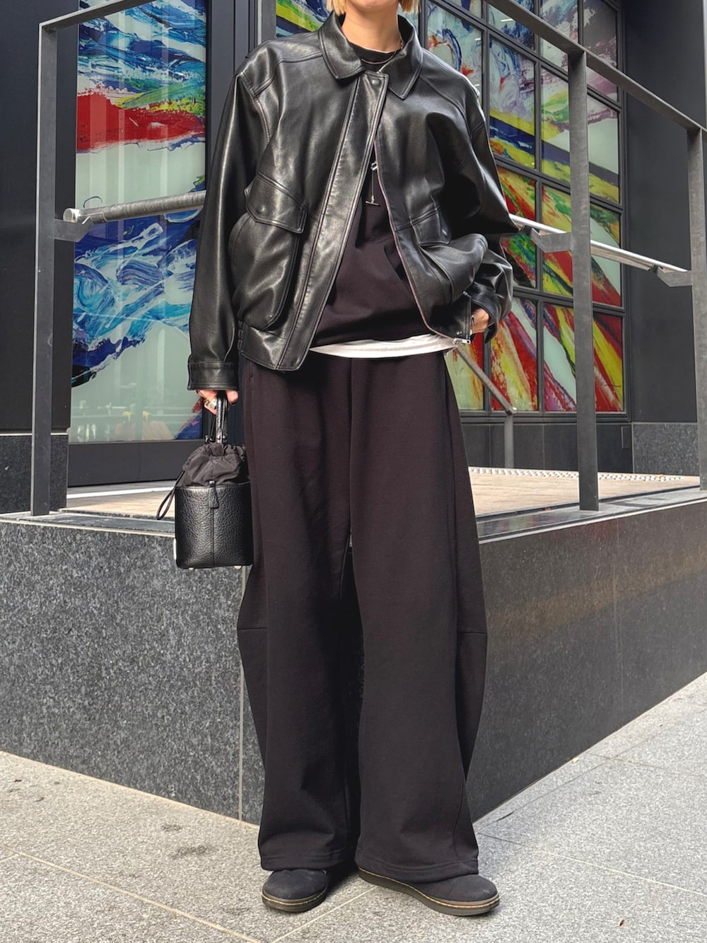 ブラック系のショルダーバッグ、ブラック系のスニーカー、ブラック系のスウェットパンツを着用したレディースの冬コーディネートの2枚目の写真