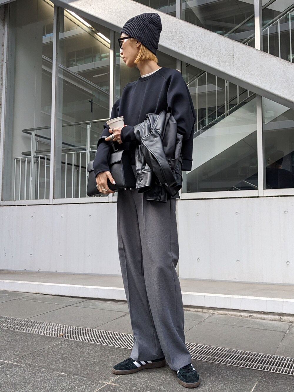 ブラック系のスウェット、ブラック系のバッグ、ブラック系のスニーカーを着用したレディースの冬コーディネートの2枚目の写真