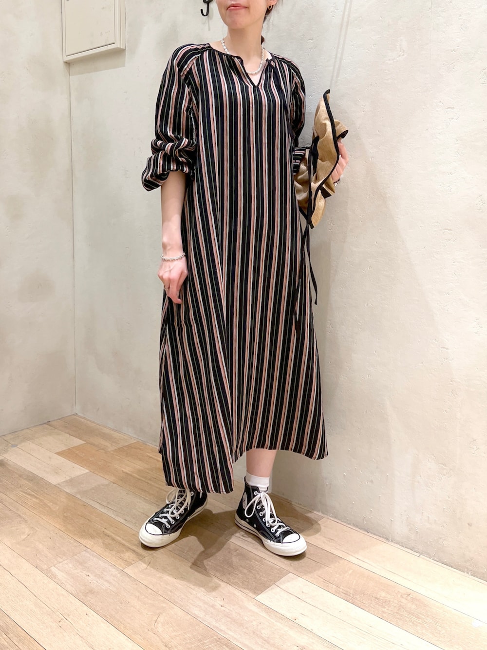 ブラック系のワンピース、ベージュ系のハットを着用したレディースの春コーディネートの2枚目の写真