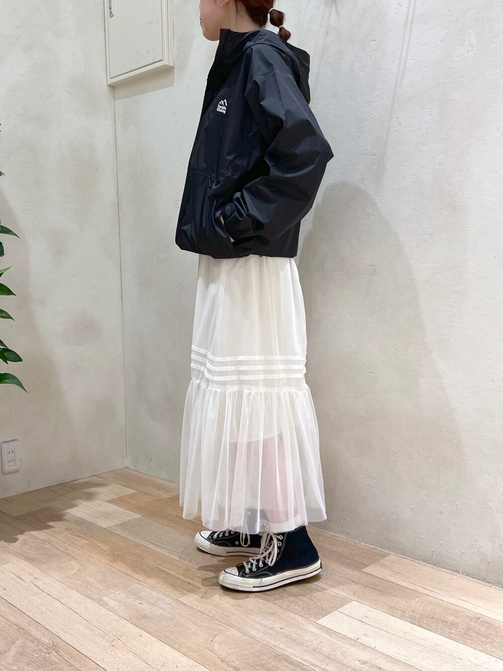 ホワイト系のワンピース、イエロー系のタンクトップ、ブラック系のマウンテンパーカーを着用したレディースの春コーディネートの3枚目の写真