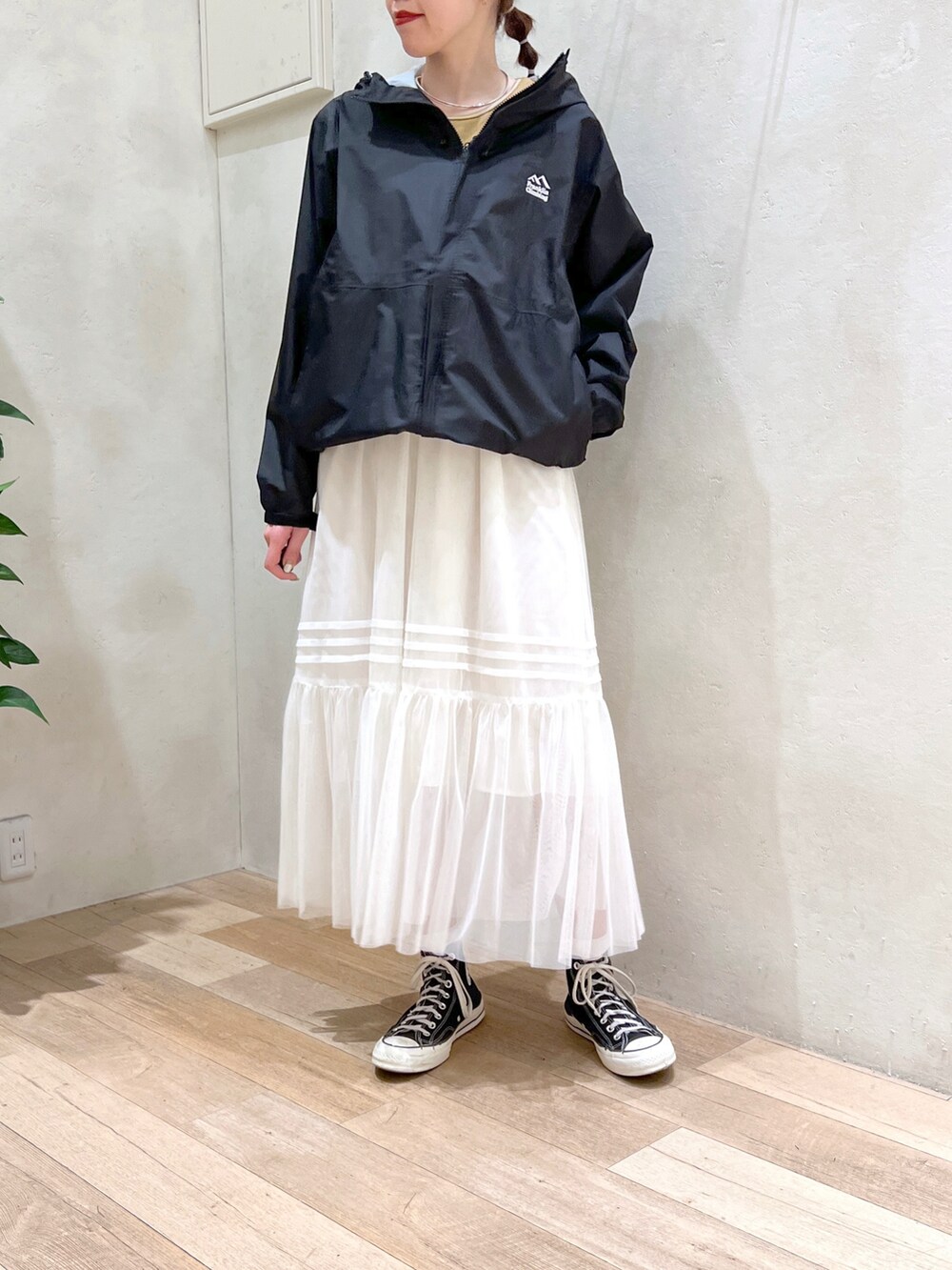 ホワイト系のワンピース、イエロー系のタンクトップ、ブラック系のマウンテンパーカーを着用したレディースの春コーディネートの2枚目の写真