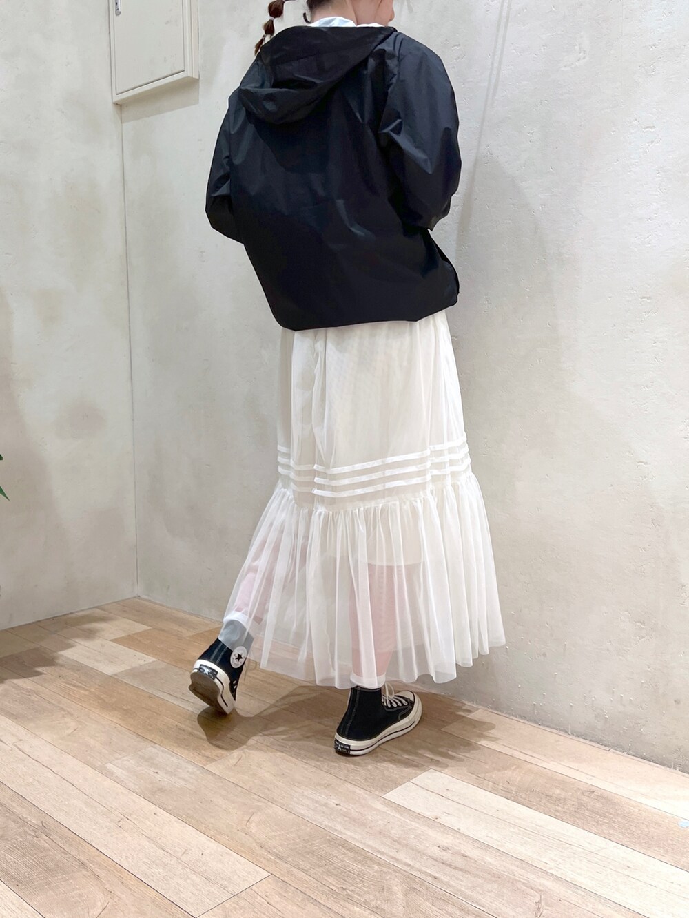 ホワイト系のワンピース、イエロー系のタンクトップ、ブラック系のマウンテンパーカーを着用したレディースの春コーディネートの5枚目の写真