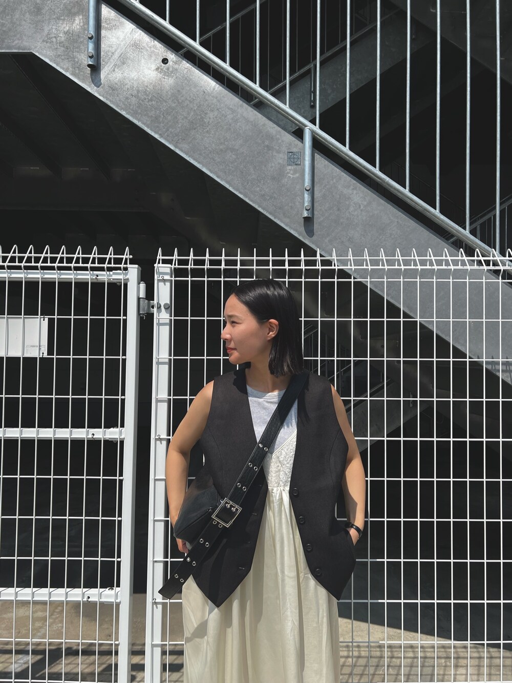 ホワイト系のワンピース、ブラック系のショルダーバッグを着用したレディースの秋コーディネートの4枚目の写真